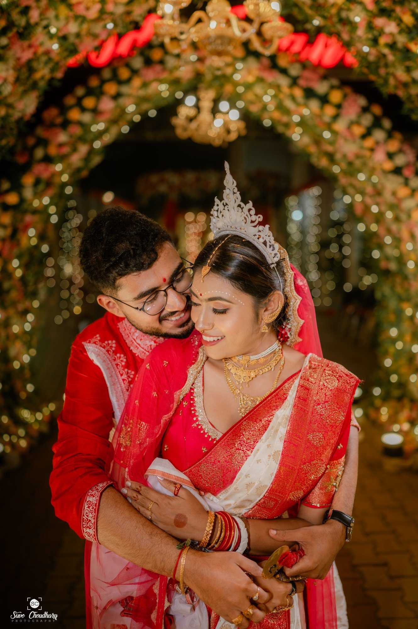 Wedding photographer in Siliguri – Bengali couple under floral arch – Suvo Choudhury